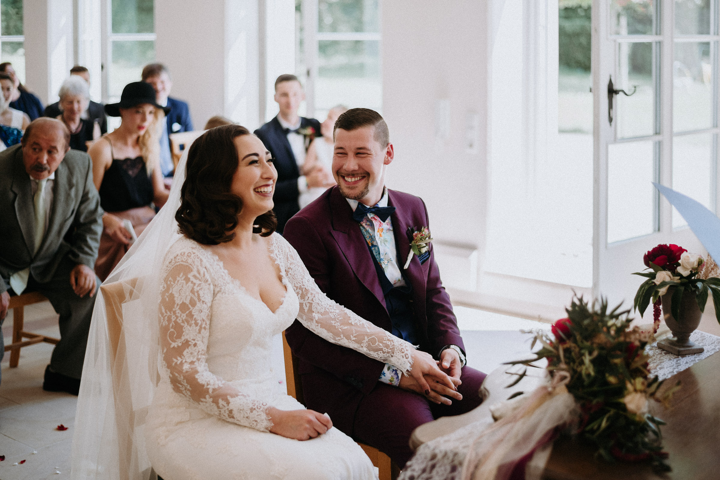 Deutsch-türkische Hochzeit: Braut und Bräutigam sitzen Hand in Hand im Trauzimmer