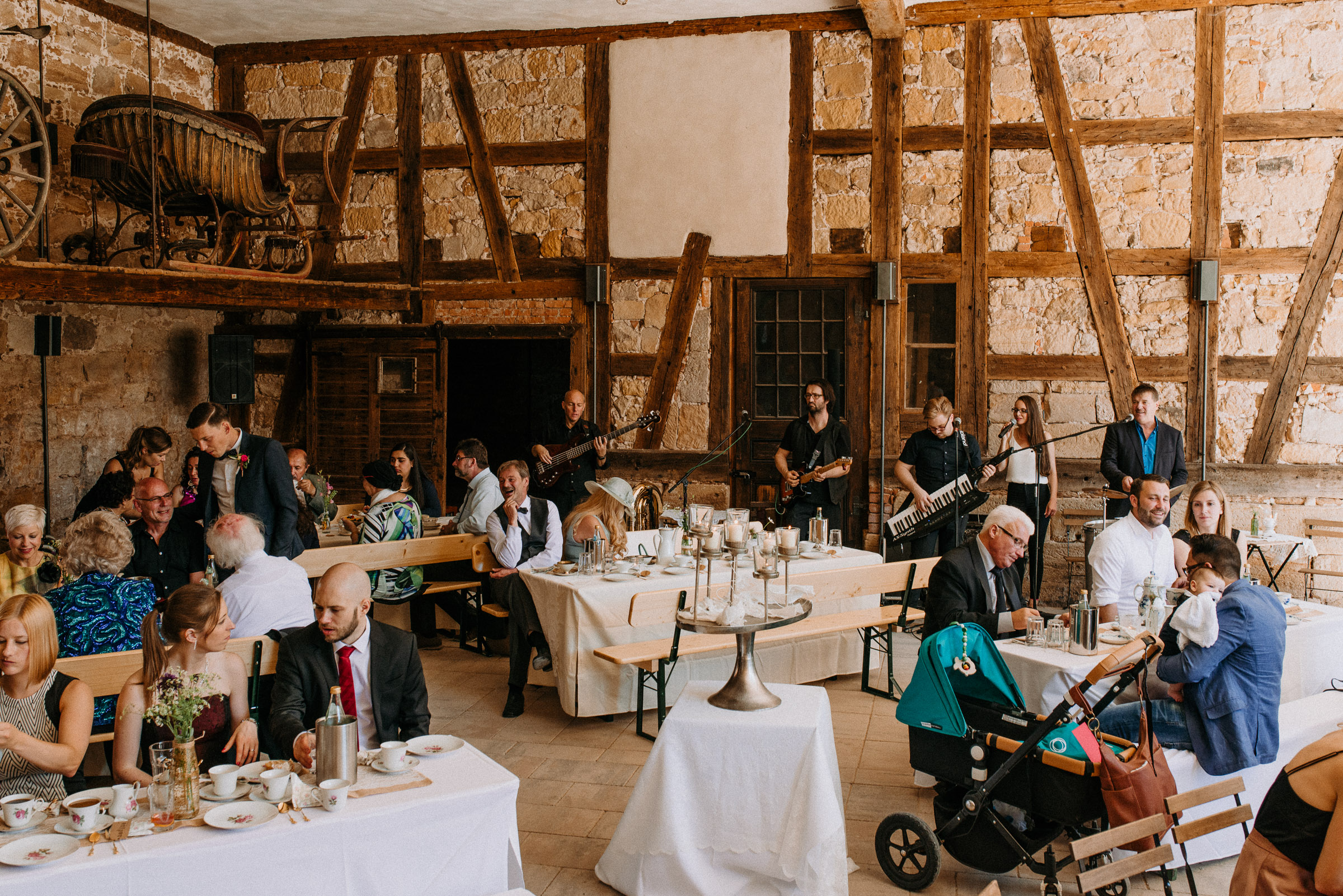 Deutsch-türkische Hochzeit: die Hochzeitsgesellschaft trinkt Kaffee in den rustikalen Arkaden des Schlosses