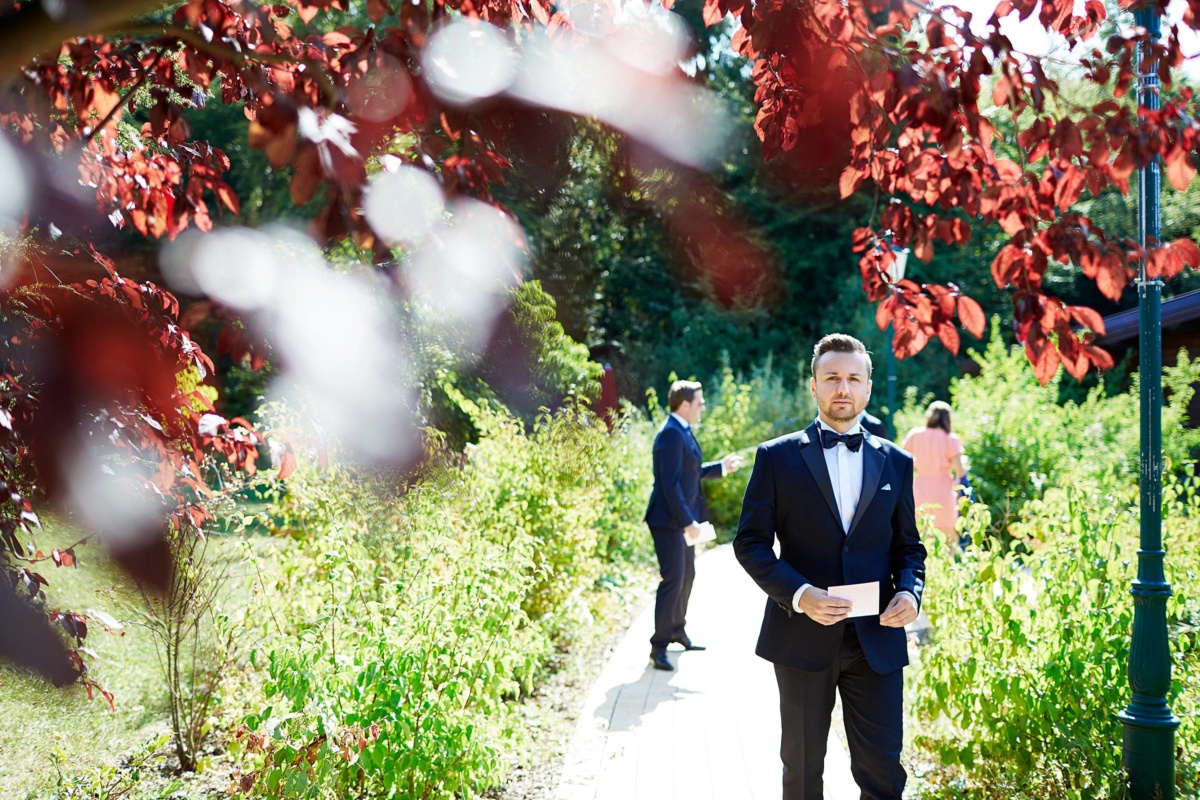 Hochzeit in einem Wellnesshotel: Bräutigam läuft durch den Garten mit Zettel in der Hand