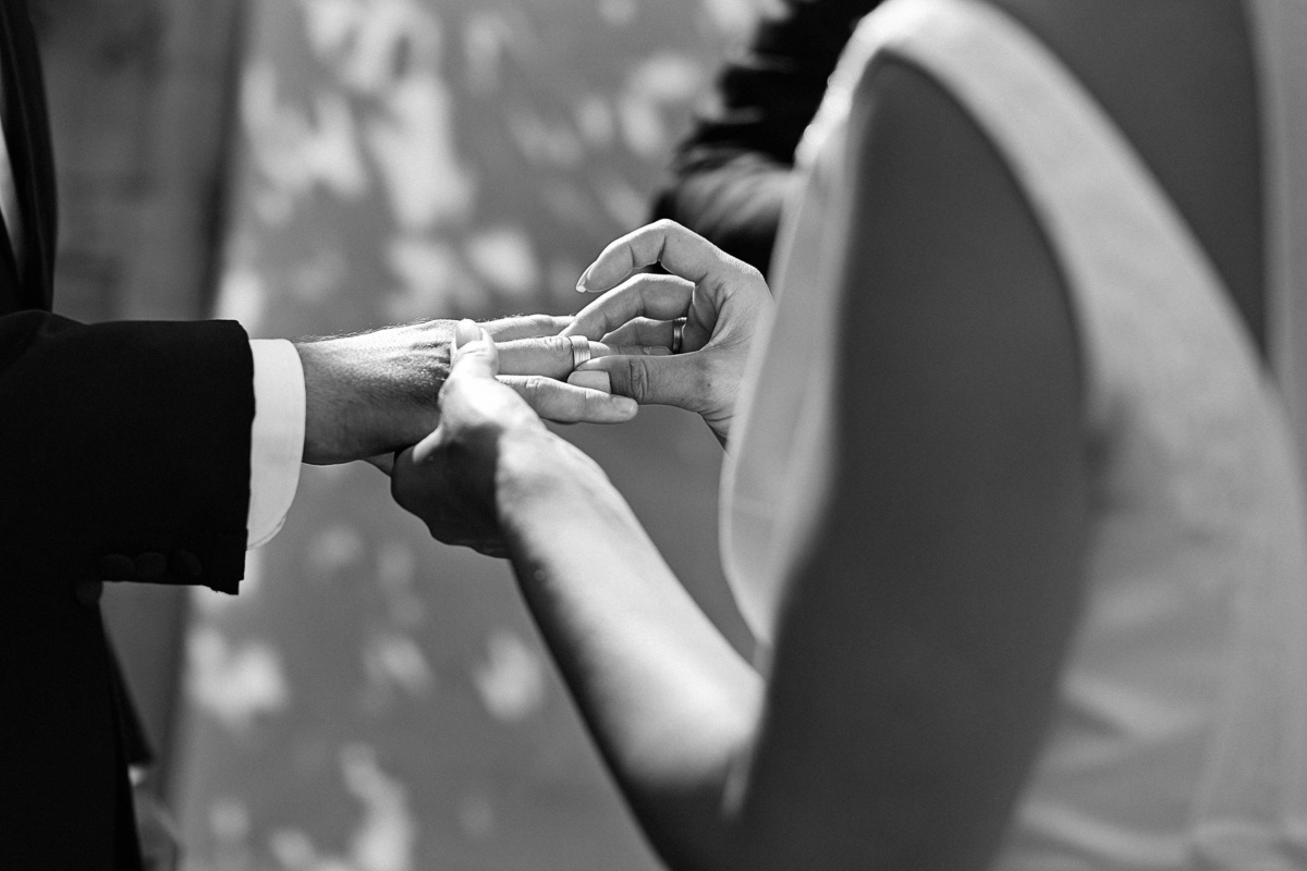 Hochzeit in einem Wellnesshotel: die Braut steckt dem Bräutigam den Ring an den Finger