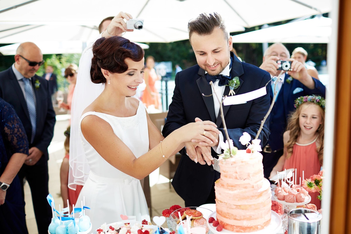 Hochzeit in einem Wellnesshotel: das Brautpaar schneidet die Hochzeitstorte an