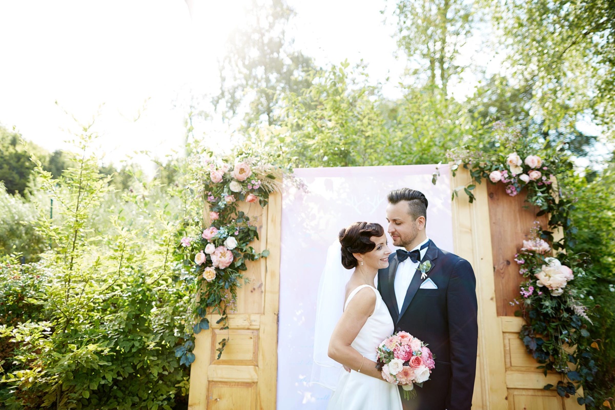 Hochzeit in einem Wellnesshotel: Brautpaarportrait vor der Blumendeko