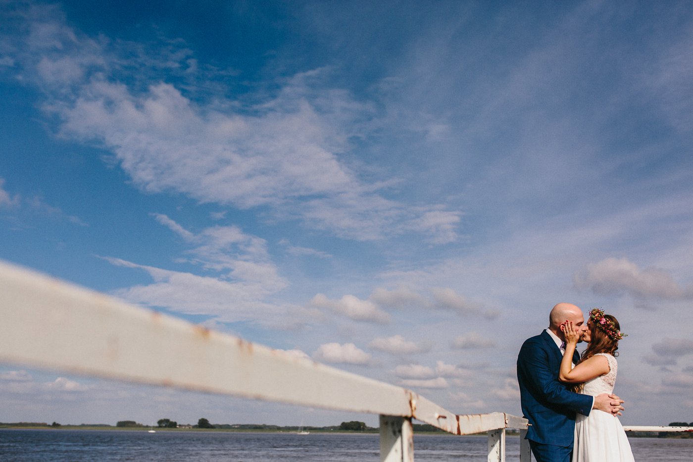 Urbane Hochzeit: Brautpaar küsst sich am Elbufer