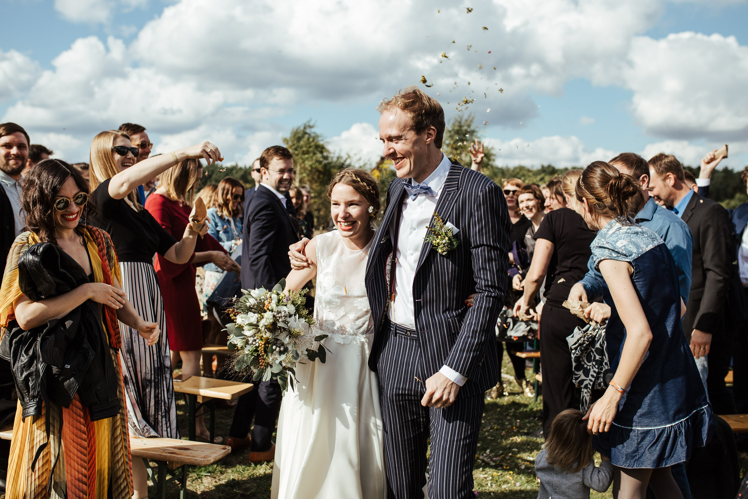 Landhochzeit: Brautpaar läuft durch das Spalier der Hochzeitsgäste