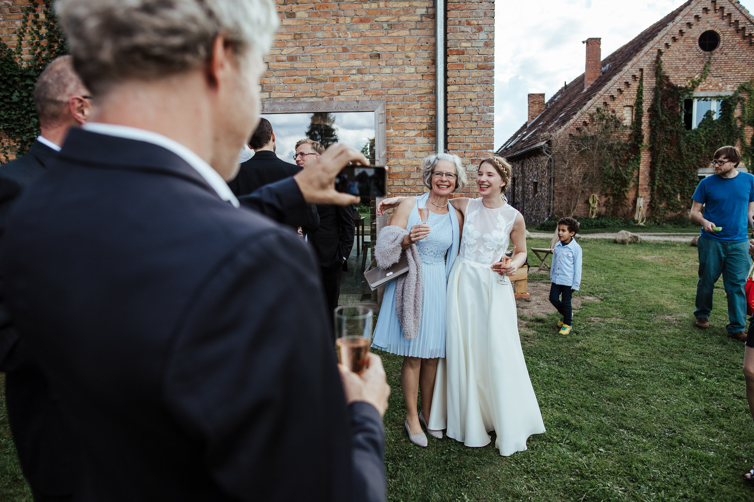 Landhochzeit: Braut wird fotografiert mit Hochzeitsgast