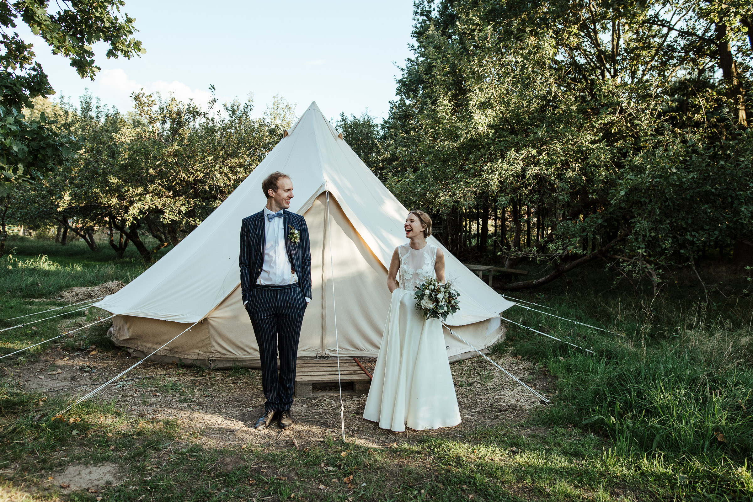 Landhochzeit: Brautpaar vor dem Zelt